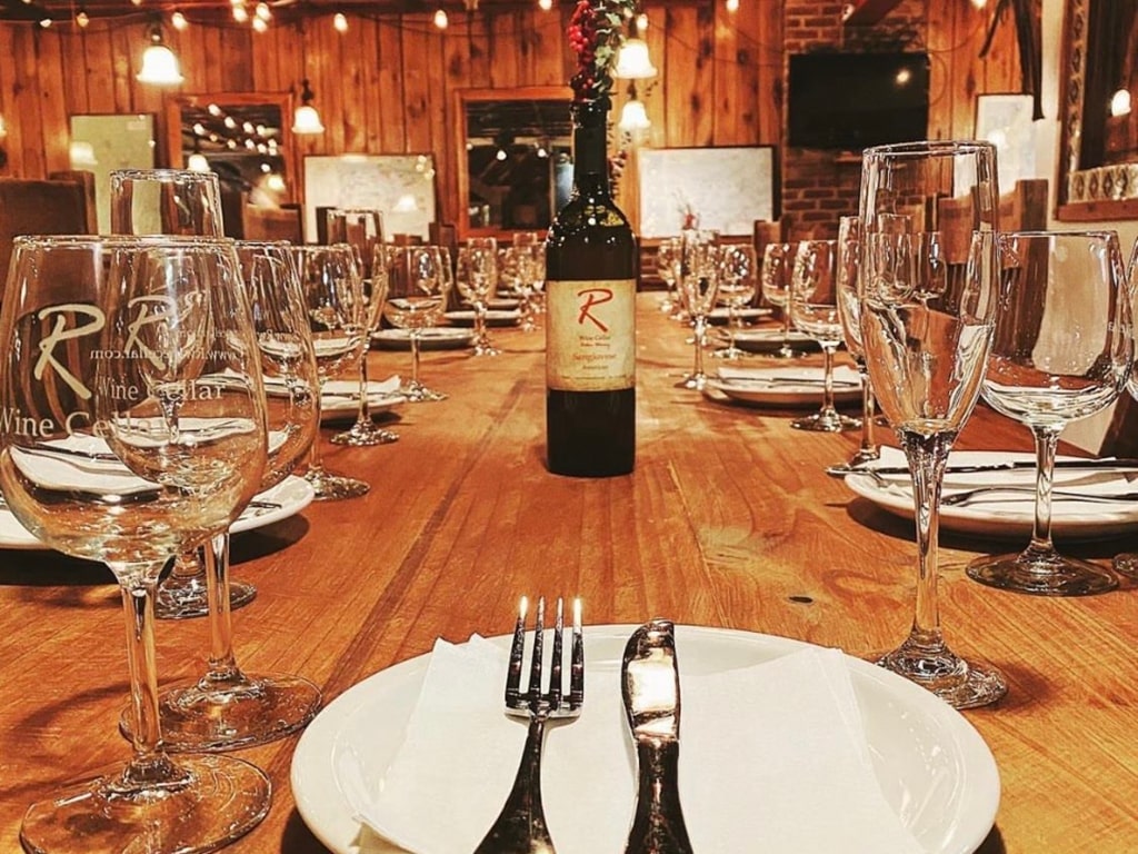 R Wine Cellar table at Penn Ave location with wine in the center of the table